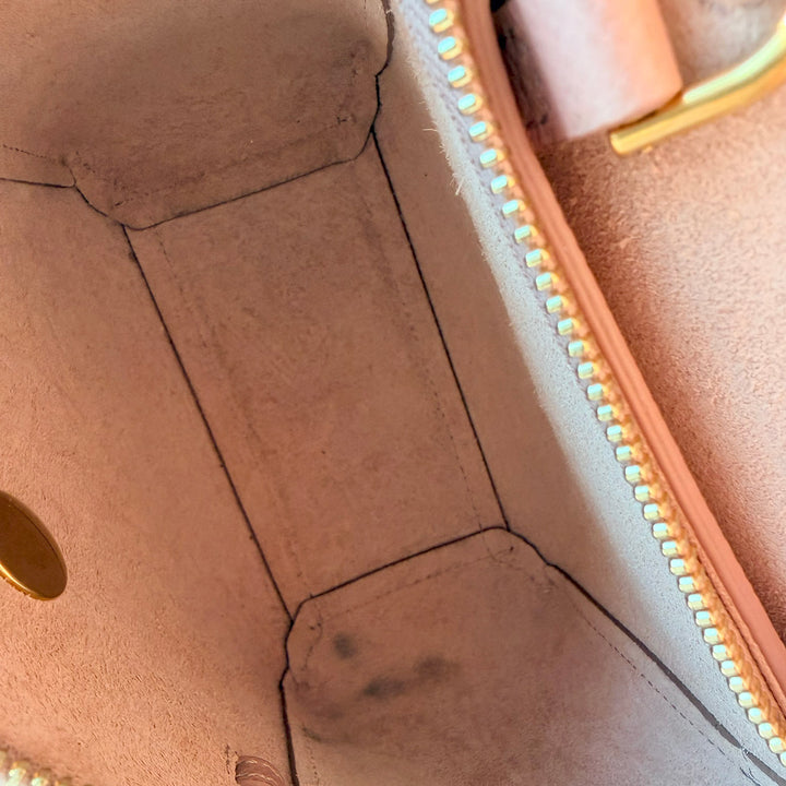 Close-up of a brown leather bag with gold accents